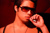 young man in sunglasses with a cigarette inside a club